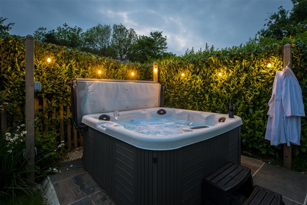 Threshing Barn hot tub open with evening festoon lights